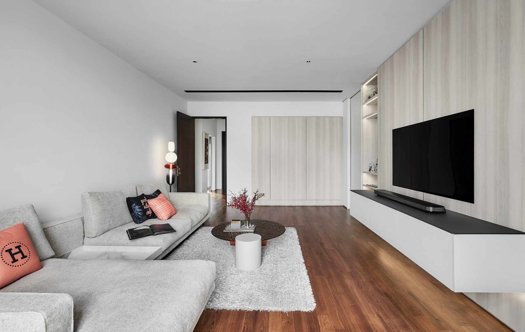 Living area with pale timber joinery, a wall-mounted television and warm hardwood flooring at the Namly Hill residence.